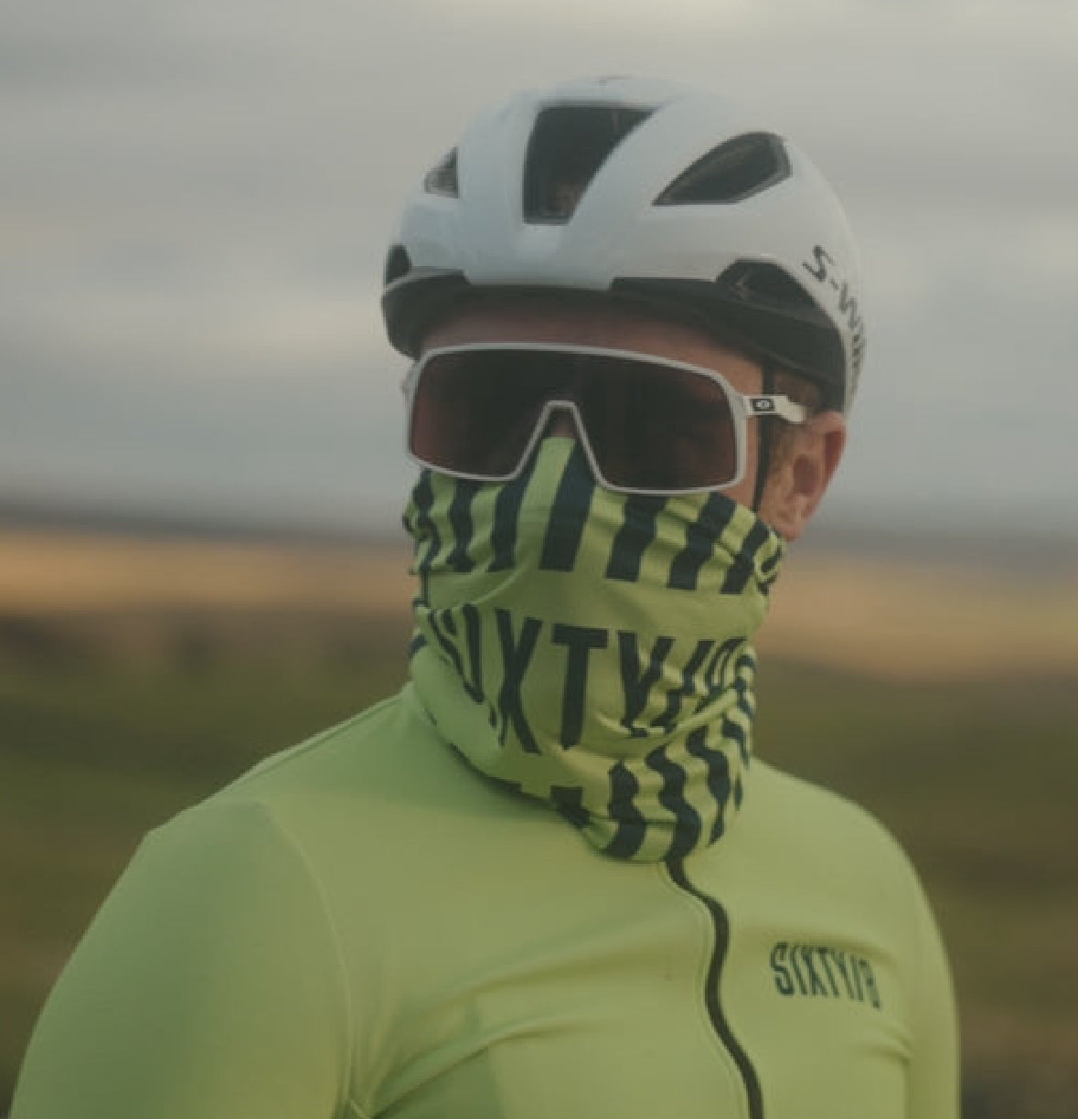 Cyclist wearing SIXTY/8 tennis-ball yellow and navy cycling neck warmer pulled over the lower face