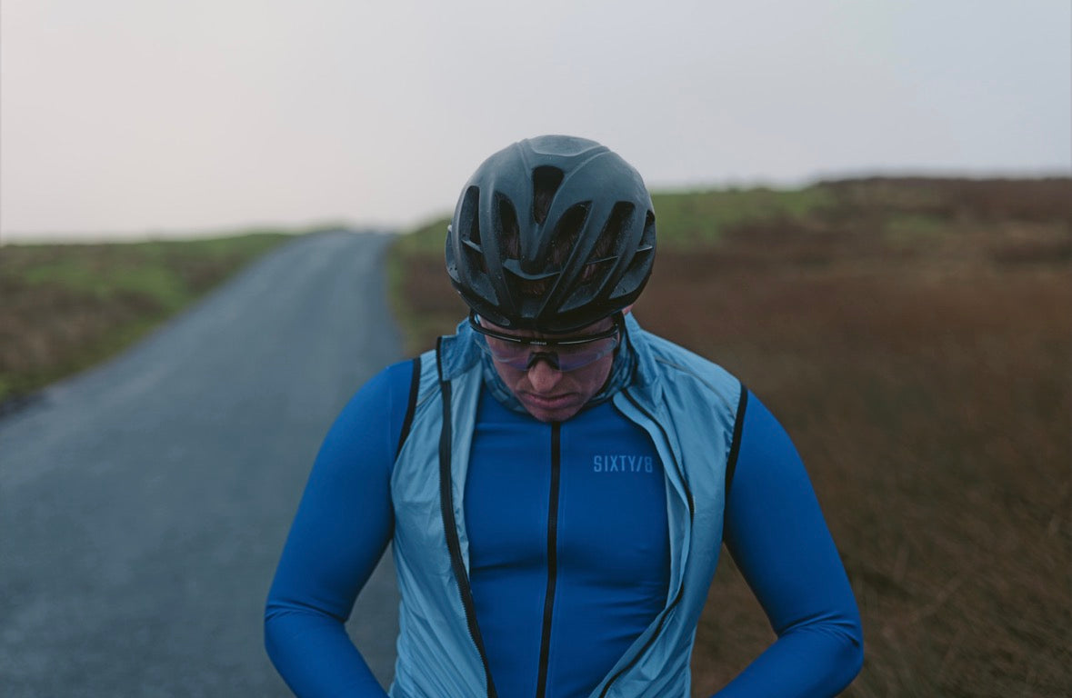 Cyclist wearing the SIXTY/8 Danbrook azure blue long sleeve cycling jersey, showing the front zip and fit.
