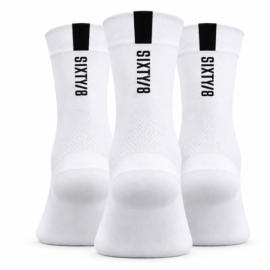 Three pairs of SIXTY/8 white cycling socks shown from the rear, featuring black vertical SIXTY/8 logos and black cuff detailing